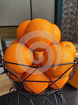 A small bucket of fresh oranges