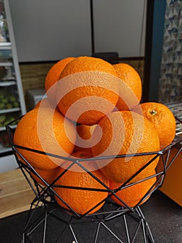 A small bucket of fresh oranges ready to be juiced for water during the day