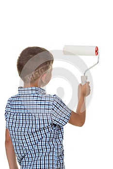 A small builder boy in blue checkered shirt, painting the wall with the paint roller, isolated on white background