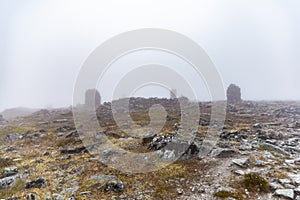Small built stone towers among stones with moss in the foggy landscape