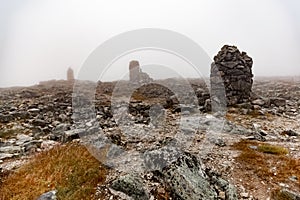 Small built stone towers among stones with moss in the foggy landscape