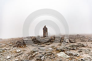 Small built stone towers among stones with moss in the foggy landscape