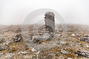 Small built stone towers among stones with moss in the foggy landscape