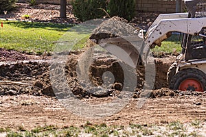 Small Bulldozer Digging In Yard For Pool Installation