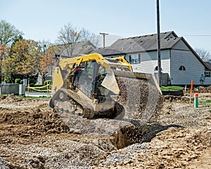 Small Bulldozer Dumping Stone in Trench