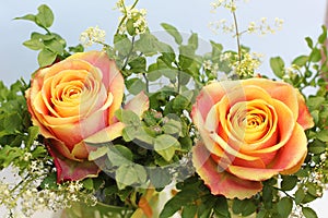 Small bunch with two orange roses and fine leaved blueberry bran
