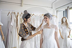 Small Business of Asian women Fashion Designer Working With Wedding Dresses at clothing store