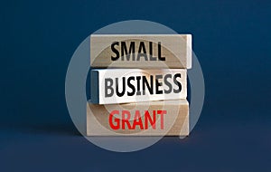 Small business grant symbol. Concept words Small business grant on wooden blocks on a beautiful grey table grey background. photo