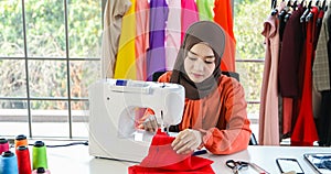Small business of Muslim woman fashion designer Working and  using smart phone and tablet With Dresses at clothing store
