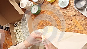 Small business owner packing and wrapping orders. Online shop seller shipping products. Female hands of worker