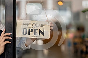 Small business owner smiling while turning the sign for the opening of the place after the quarantine due to covid-19