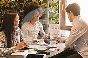 Small business owners showing presentation to investor in cafe