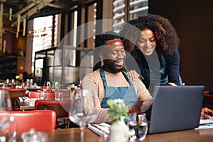 Small business owners using laptop in restaurant