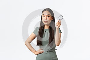 Small business owners, women entrepreneurs concept. Asian female searching for something, holding magnifying glass and