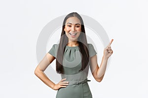 Small business owners, women entrepreneurs concept. Smiling businesswoman showing her online store link, pointing finger
