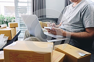 Small business parcel for shipment to client at home, Young entrepreneur SME freelance man working with note packaging sort box