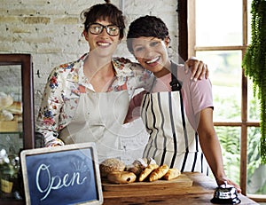 Small business partnership women friends at bakery shop smiling photo