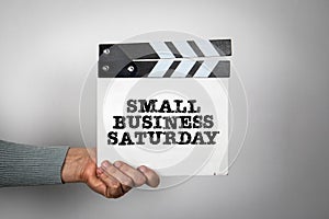 Small Business Saturday. Hand holding movie clapper