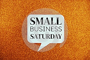 Small Business Saturday text message in white bubble speech top view on orange background