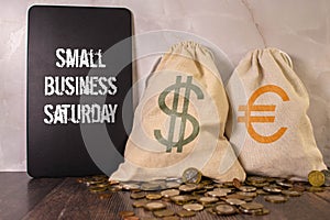 Small Business Saturday typography text on the blackboard set on wooden floor and brick background.