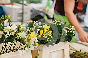 A small business for selling flowers. Street shop. The seller does the work in the background. There are different kinds