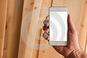 Small business woodwork entrepreneur holding smartphone with mock up screen