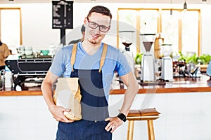 Small cafe owner holding a package of coffee beans