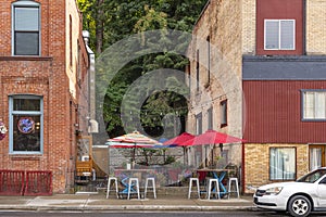 A small cafe patio with colorful umbrellas is sandwiched between two brick buildings in the historic town of Wallace, Idaho