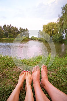 A small camping tent on the lake, a night`s lodging and the feet of a young couple