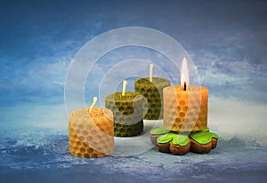 Small candles with beeswax on a blue background