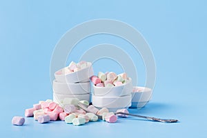 Small candy marshmallow in rosette on blue background