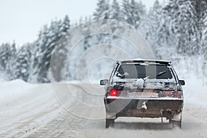 Small car driving on winter road, copyspace