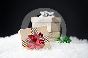 Small cardboard gift boxes with shiny holiday bows and striped r