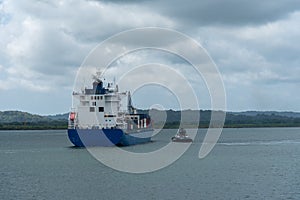 Small cargo container ship sailing through Panama Canal.