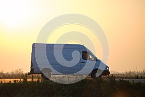 Small cargo van driving on highway hauling goods. Delivery transportation and logistics concept