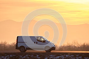 Small cargo van driving on highway hauling goods. Delivery transportation and logistics concept