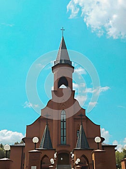 A small Catholic church against a blue sky