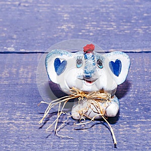 Small ceramic baby elephant on a wooden background