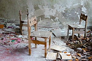 Small chairs among dirt and debris in abandoned kindergarten, dead city of Pripyat, Chernobyl NPP exclusion zone, Ukraine