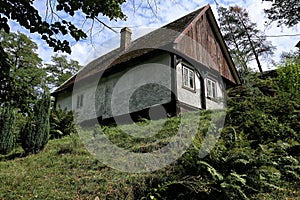 Small chalet with wooden gable on the top of grassy hill