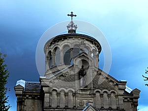 Gloomy view of the Sainte-Beatrix chapel, closeup, against the dark evening sky with heavy rain clouds photo