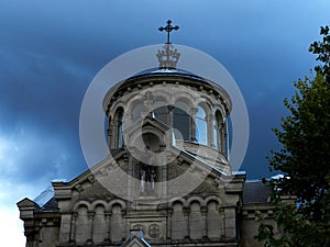 Gloomy view of the Sainte-Beatrix chapel, closeup, against the dark evening sky with heavy rain clouds photo
