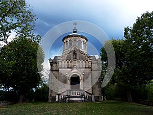 Gloomy view of the Sainte-Beatrix chapel against a dark evening sky with heavy rain clouds photo