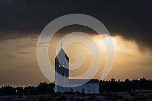 a small chapel on the hill at sunset