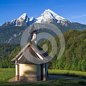 Small chapel Kirchleitn and snow-capped summits of Watzmann mountain photo