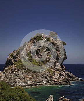 A small chapel on top of the rock in Greek island