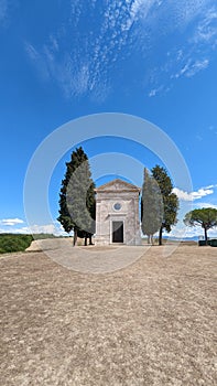 Small Chapel Vitaleta (Cappella della Madonna di Vitaleta) iin Italy under bright blue sky