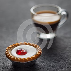 Small cherry cake with a glass of fresh espresso