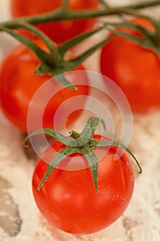 Small cherry tomatoes on a table smeared with flour.