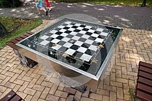 A small chess table in the park. Empty board game table